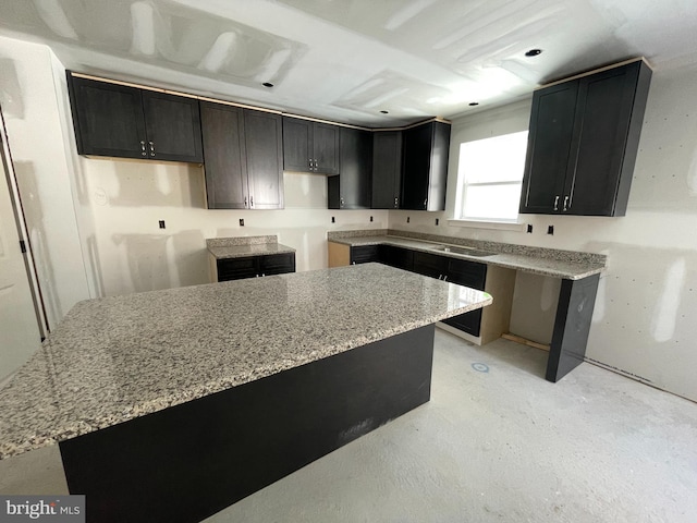 kitchen featuring light stone countertops and sink