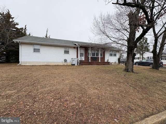 view of front of home featuring covered porch and a front lawn