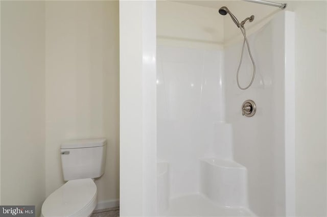 bathroom featuring a shower and toilet