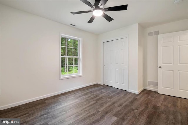 unfurnished bedroom with dark hardwood / wood-style flooring, a closet, and ceiling fan