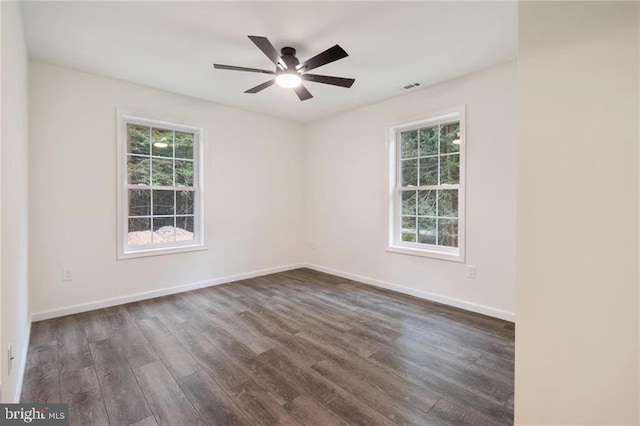 empty room featuring dark hardwood / wood-style floors, a wealth of natural light, and ceiling fan