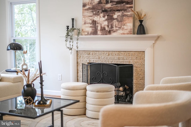 living area featuring baseboards and a tiled fireplace