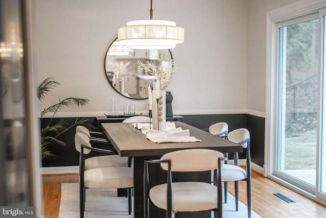 dining area featuring light wood-style floors, baseboards, and visible vents