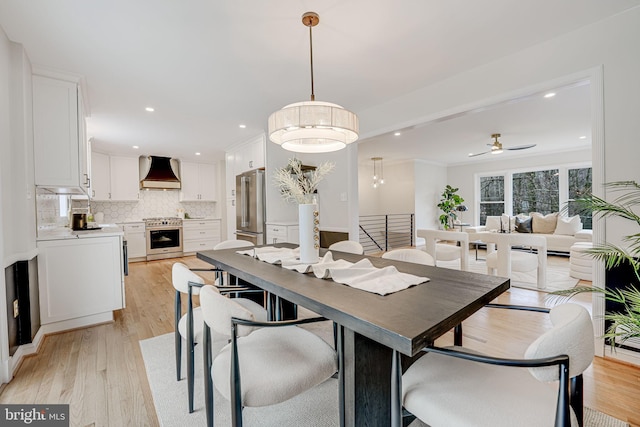 dining space with light wood finished floors, ceiling fan, and recessed lighting