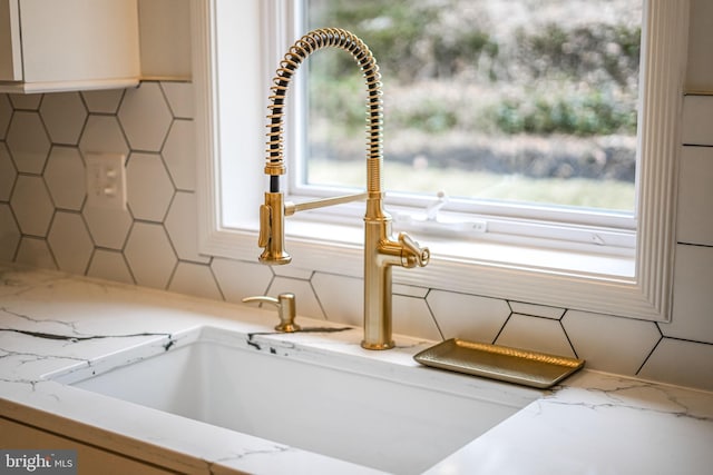 interior details featuring light stone counters and tasteful backsplash