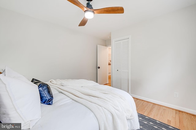 bedroom with a ceiling fan, a closet, baseboards, and wood finished floors