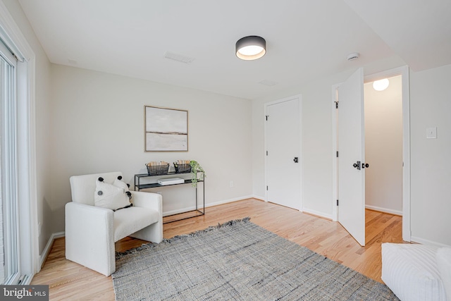 living area featuring light wood finished floors and baseboards