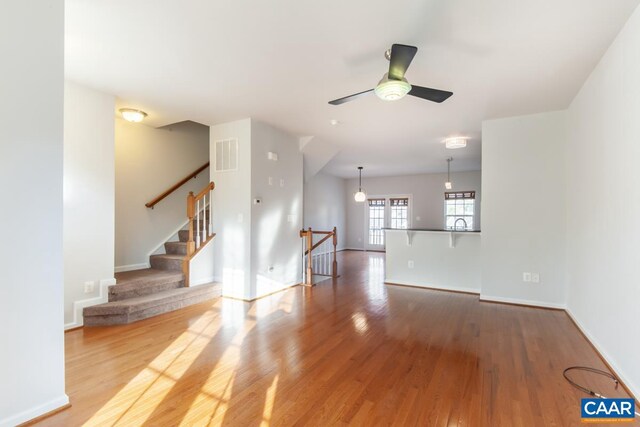 unfurnished living room with hardwood / wood-style floors and ceiling fan