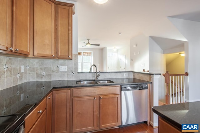 kitchen with sink, dark stone countertops, dark hardwood / wood-style flooring, decorative backsplash, and stainless steel dishwasher