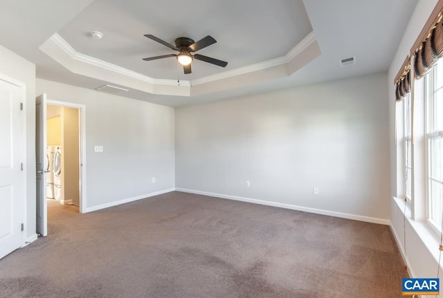 unfurnished room featuring crown molding, washer and clothes dryer, a raised ceiling, and ceiling fan