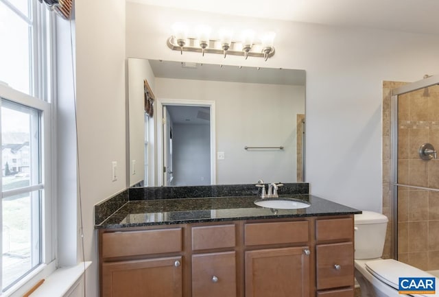 bathroom with walk in shower, vanity, and toilet