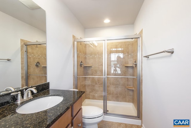 bathroom with vanity, tile patterned flooring, toilet, and walk in shower