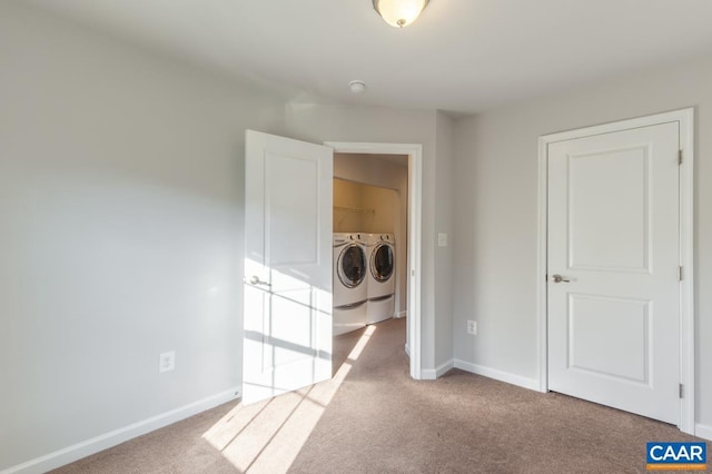 clothes washing area with washer and clothes dryer and light carpet