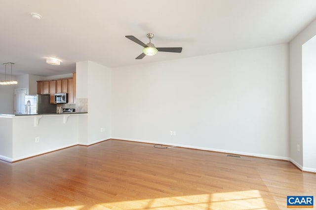 unfurnished living room with ceiling fan and light wood-type flooring