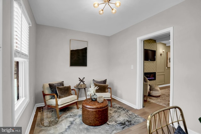 living area featuring hardwood / wood-style flooring, a chandelier, and a fireplace