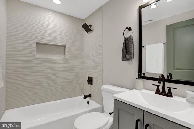 full bathroom with tiled shower / bath combo, vanity, and toilet