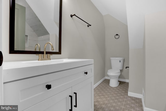 bathroom with vanity, lofted ceiling, and toilet