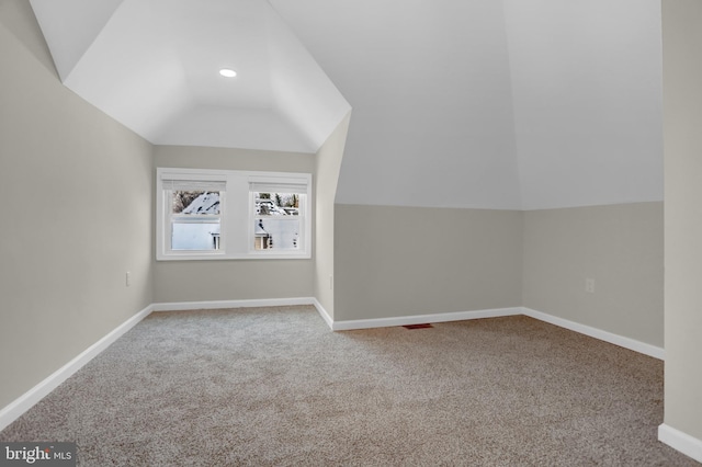 additional living space with vaulted ceiling and carpet floors