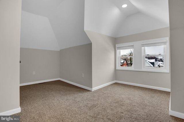 additional living space featuring lofted ceiling and carpet flooring