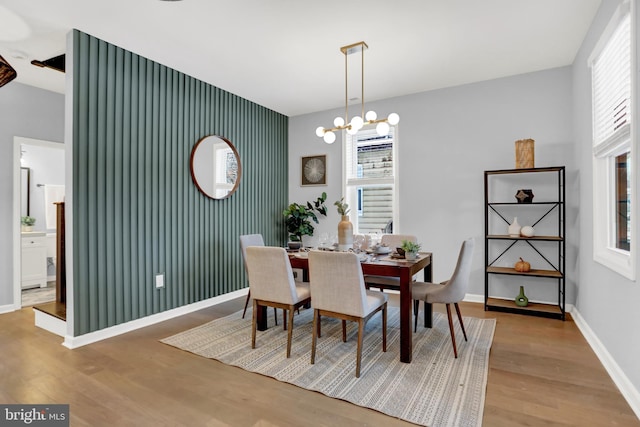 dining space with hardwood / wood-style flooring and an inviting chandelier