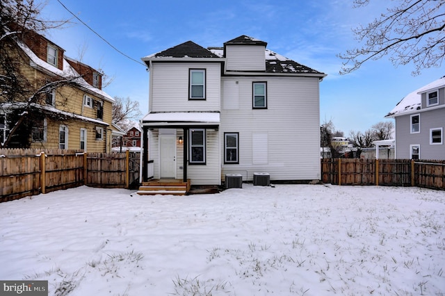 snow covered property with central AC unit