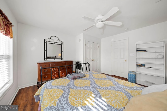 bedroom featuring ceiling fan, dark wood-style flooring, a closet, and baseboards