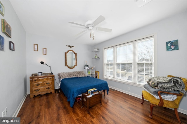 bedroom with a ceiling fan, wood finished floors, visible vents, and baseboards