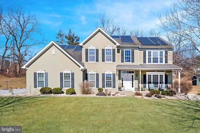 view of front of house with covered porch, roof mounted solar panels, a front lawn, and roof with shingles