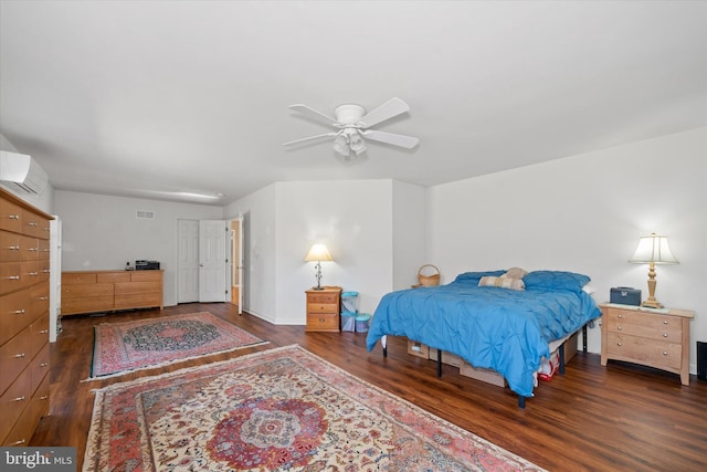 bedroom featuring a wall mounted AC, wood finished floors, visible vents, and a ceiling fan