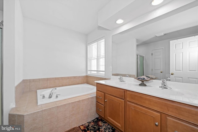 full bathroom with a garden tub, a sink, a shower with door, and double vanity