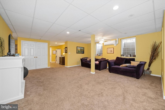 carpeted living room with an AC wall unit, recessed lighting, a paneled ceiling, and baseboards