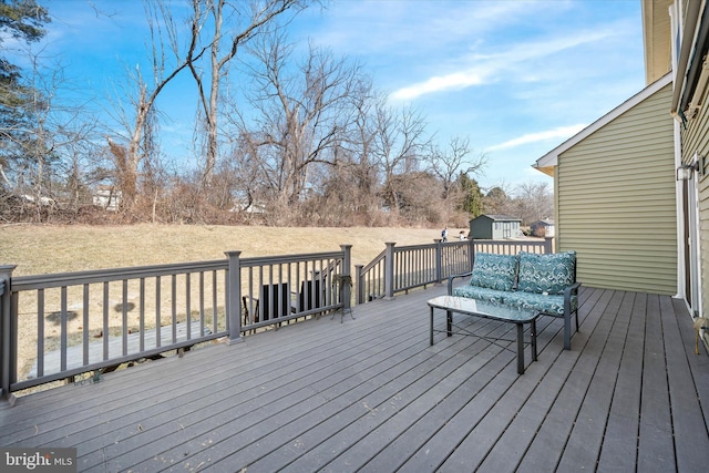 wooden terrace featuring a storage shed and an outbuilding