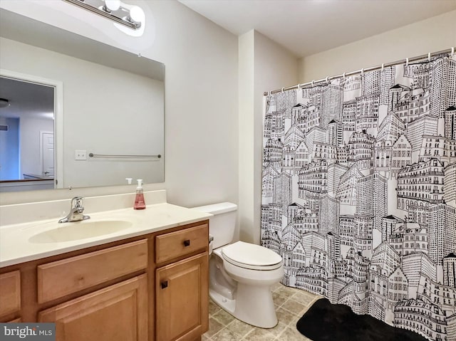 bathroom featuring toilet, curtained shower, and vanity