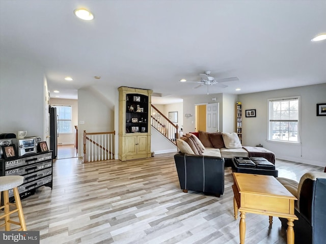 living area with light wood-style floors, recessed lighting, stairway, and baseboards