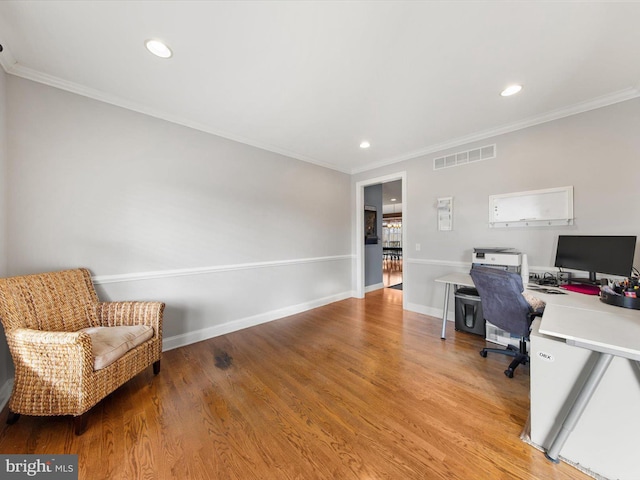 office area featuring visible vents, baseboards, crown molding, and light wood finished floors
