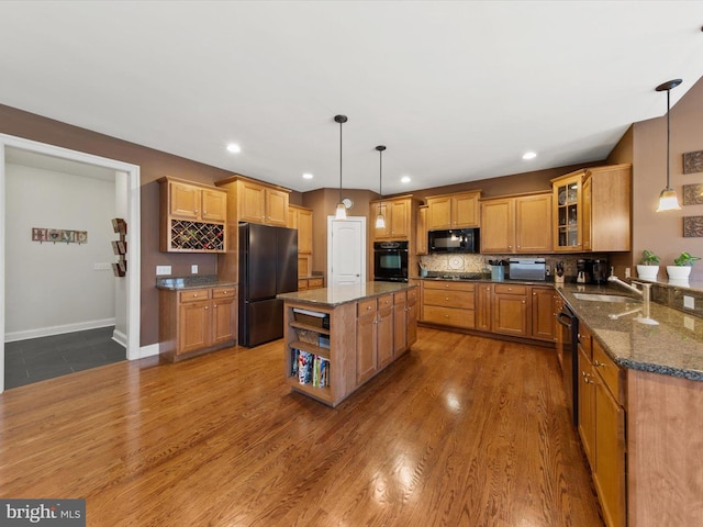 kitchen featuring tasteful backsplash, dark stone countertops, black appliances, and dark wood-type flooring