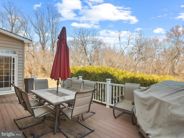 wooden deck with outdoor dining area and a grill