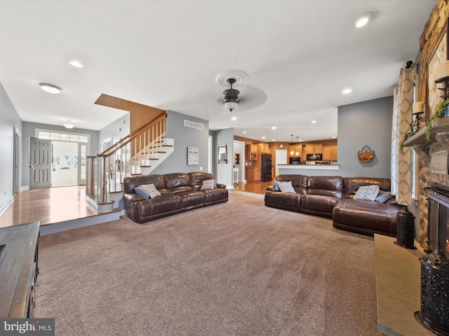 living area featuring stairs, carpet flooring, a fireplace, and recessed lighting