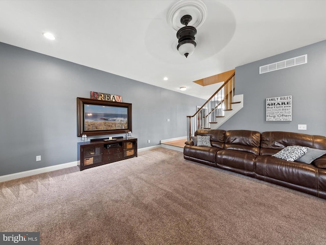 living room with stairway, carpet flooring, visible vents, and ceiling fan