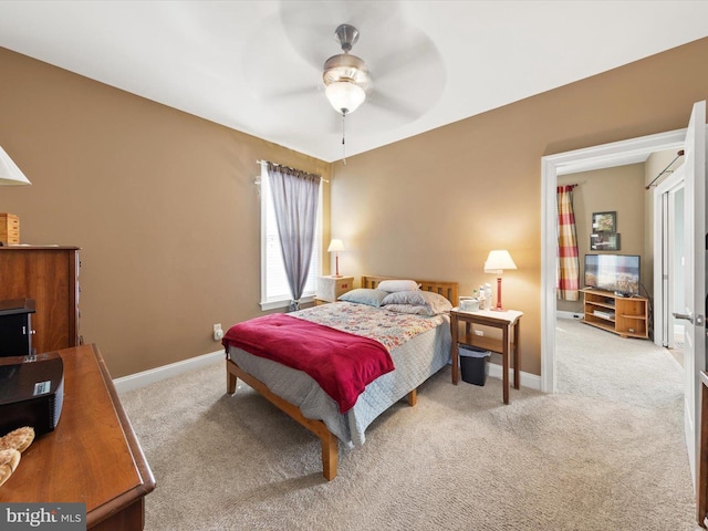 carpeted bedroom featuring baseboards and a ceiling fan
