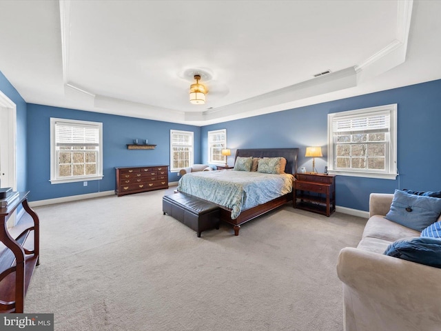 bedroom with a raised ceiling, carpet flooring, baseboards, and visible vents