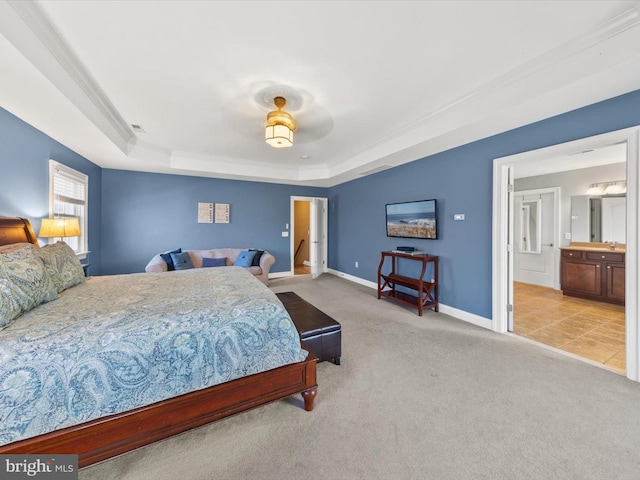 carpeted bedroom featuring visible vents, baseboards, ornamental molding, ensuite bathroom, and a raised ceiling