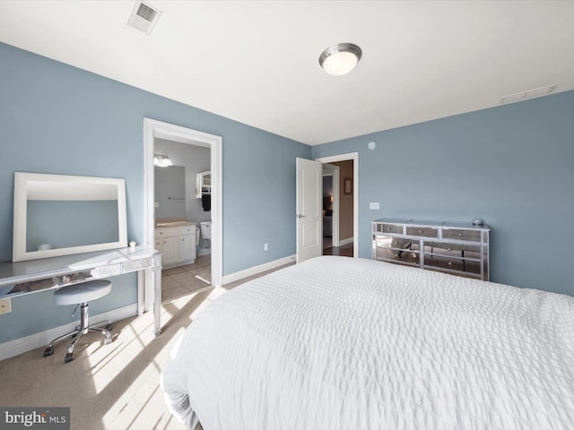 carpeted bedroom featuring visible vents, baseboards, and connected bathroom