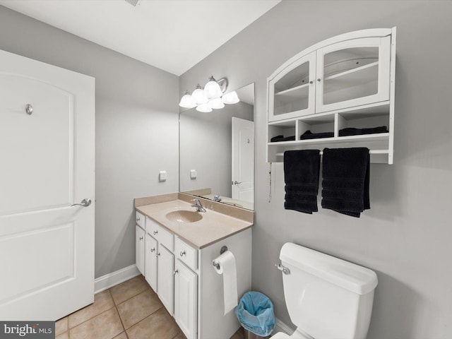 half bath featuring vanity, tile patterned floors, toilet, and baseboards