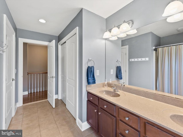 bathroom featuring a sink, double vanity, and tile patterned flooring