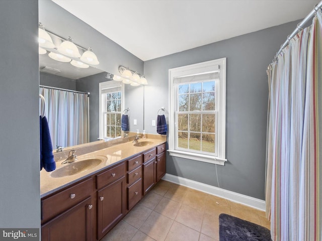 bathroom featuring a sink, baseboards, and plenty of natural light