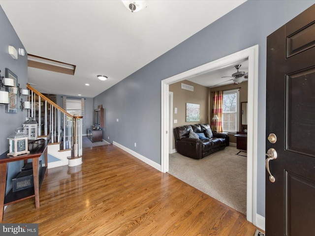 entryway featuring stairs, light wood-style flooring, visible vents, and baseboards
