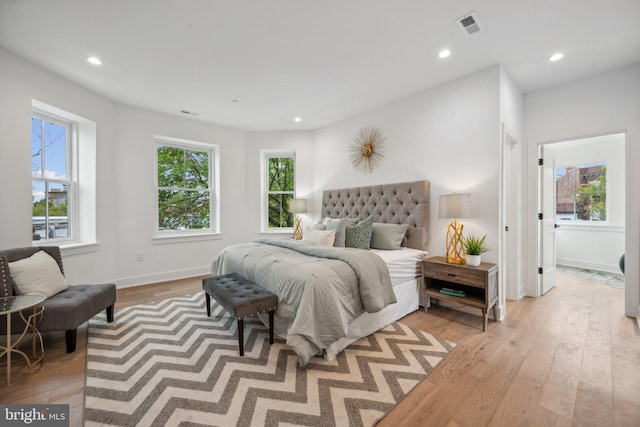 bedroom with multiple windows and light wood-type flooring