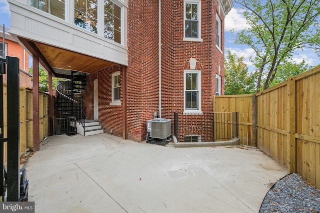 view of side of property featuring a patio and central AC