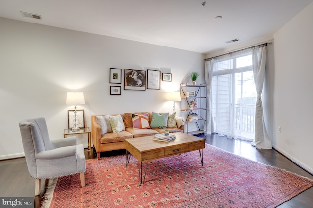 living area featuring wood finished floors, visible vents, and baseboards